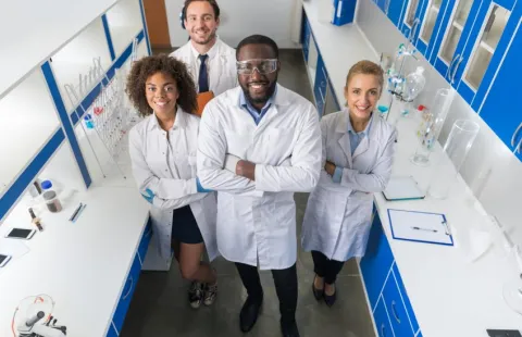 People in lab coats standing in a laboratory